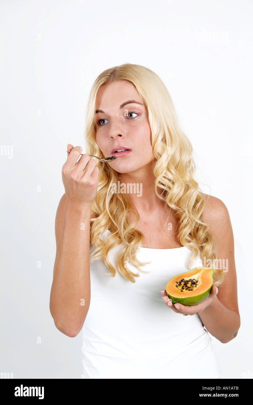 Lifestyle young 20+ woman enjoying a papaw Wellfood health living Stock Photo