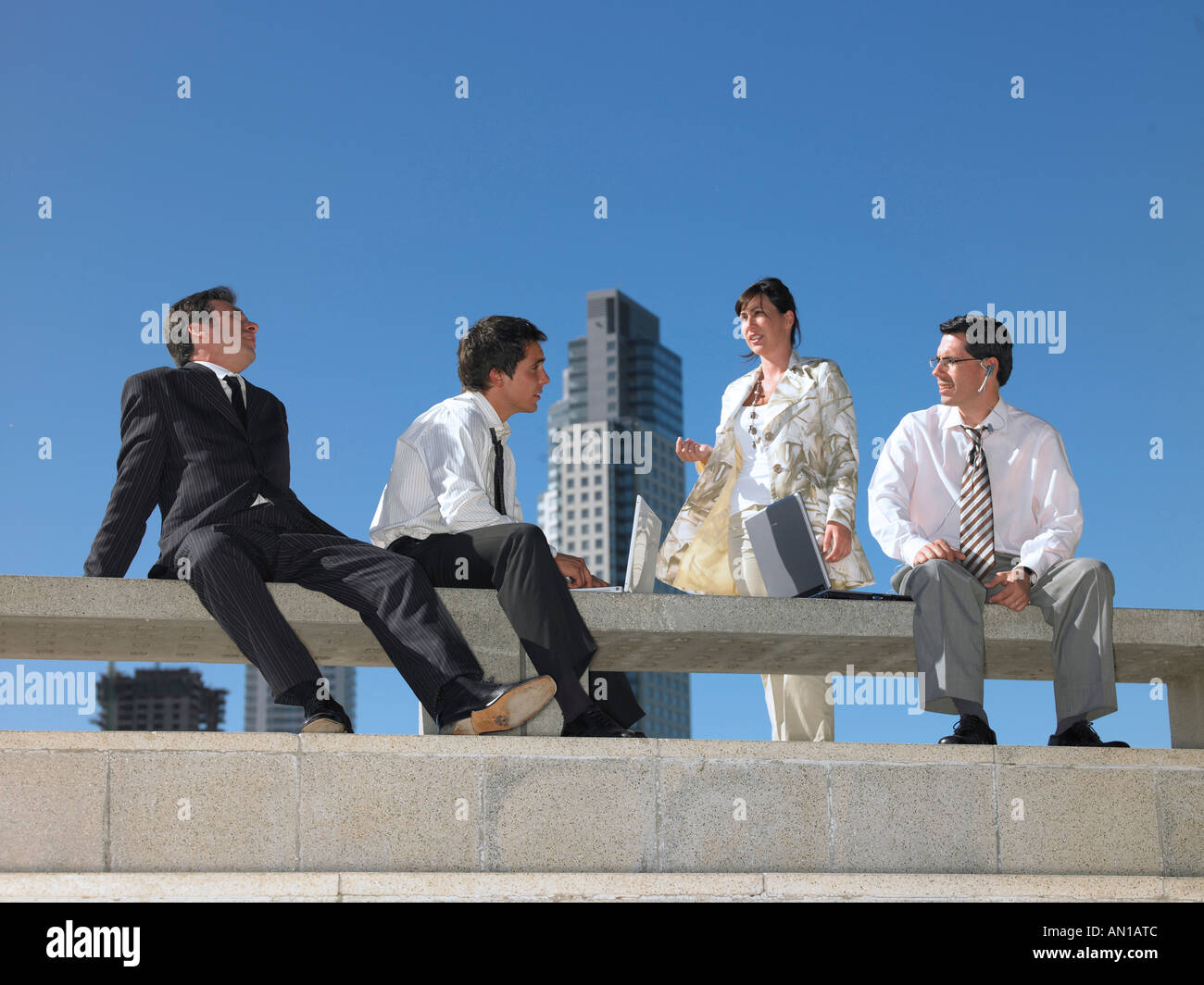 Four people chatting on a sunny day Stock Photo