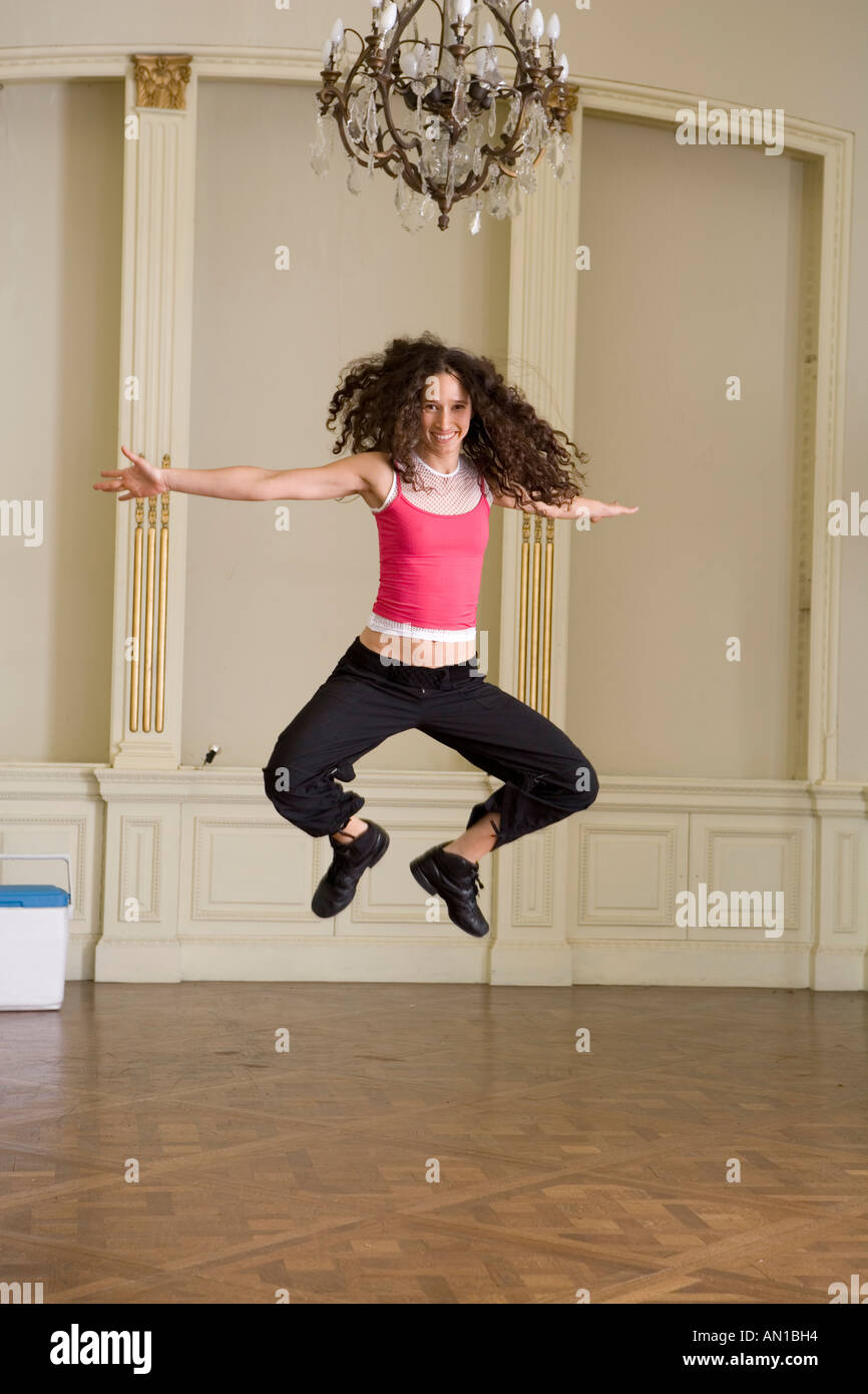 Young woman jumping in dance class Stock Photo