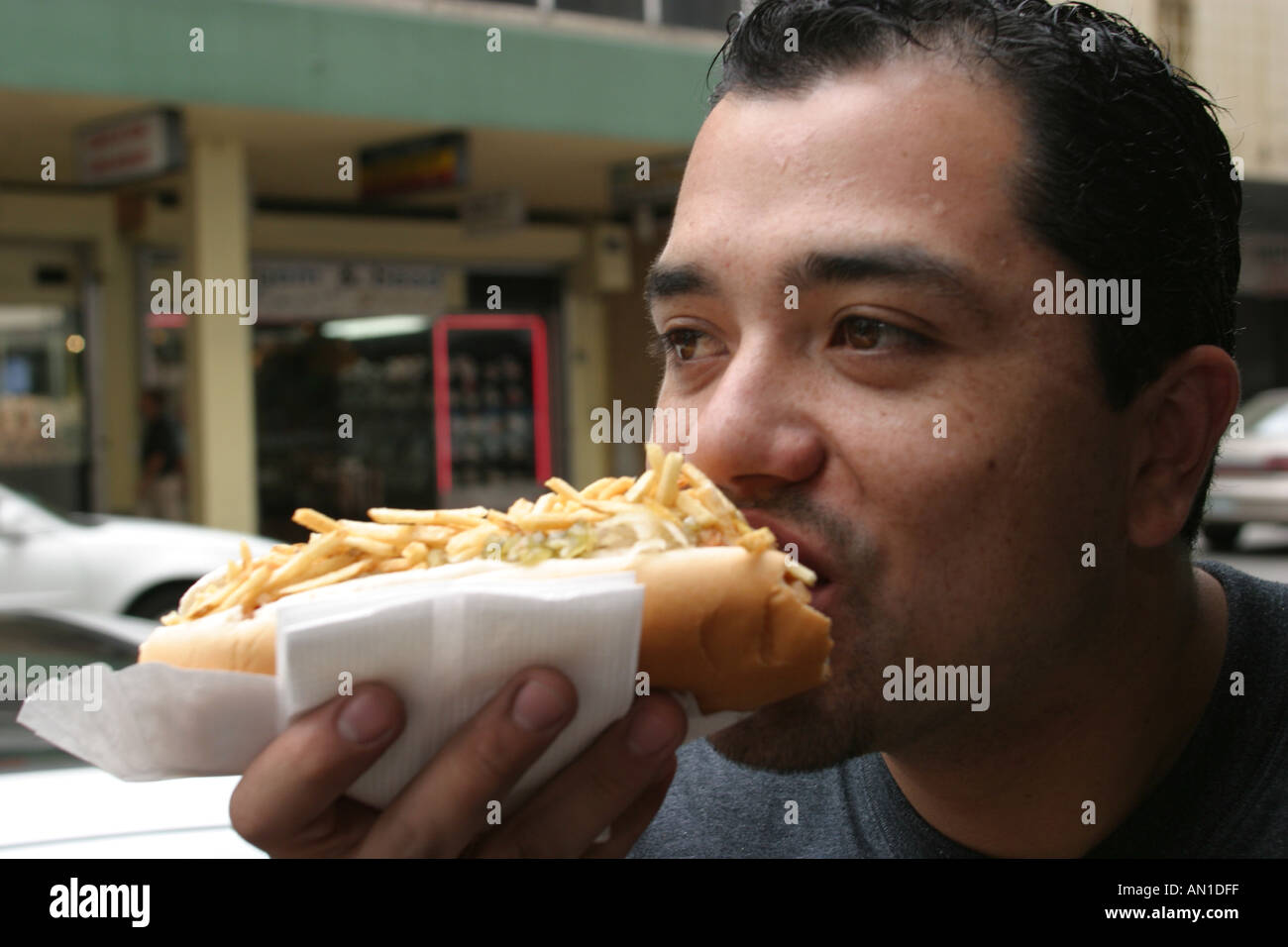 Miami Florida,Flagler Street,Hispanic Latin Latino ethnic immigrant immigrants minority,adult adults man men male,eating chili dog dogs,Man's Best Fri Stock Photo