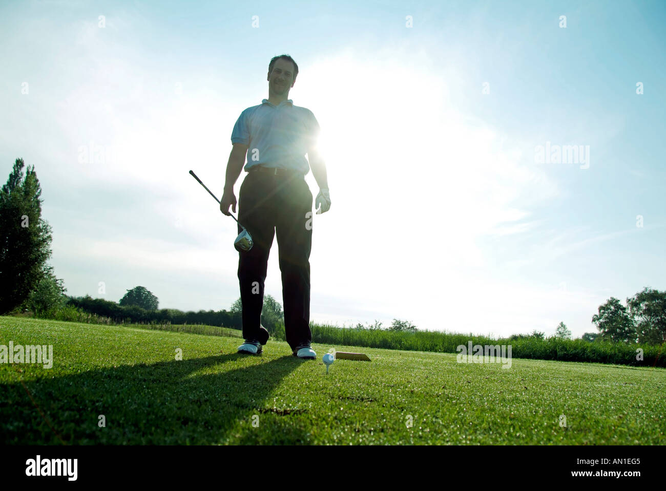 Golf Golfing Golfsport, close-up of a golf player hitting his ball at first hole, backlight Stock Photo
