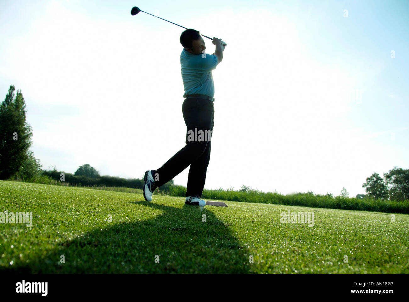 Golf Golfing Golfsport, close-up of a golf player hitting his ball at first hole, backlight Stock Photo