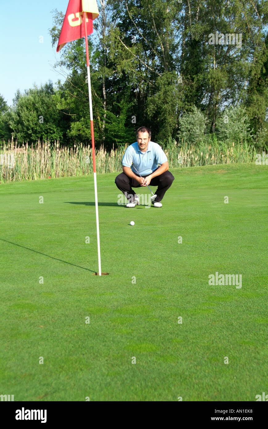 Golf Golfing Golfsport, a golf player concentrating on his hole on greenfee Stock Photo