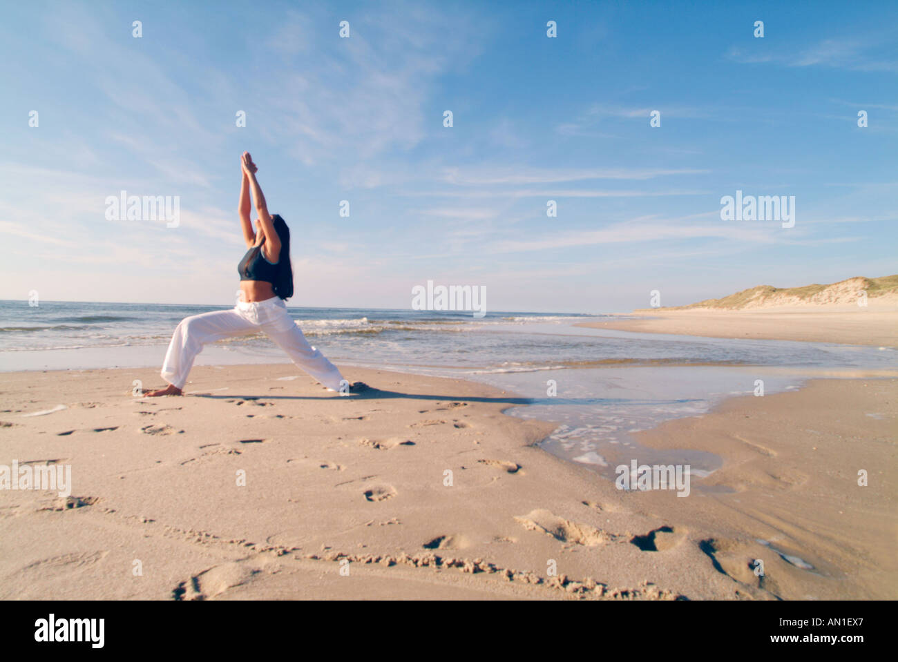 young woman doing Yoga exercises at the beach Stock Photo