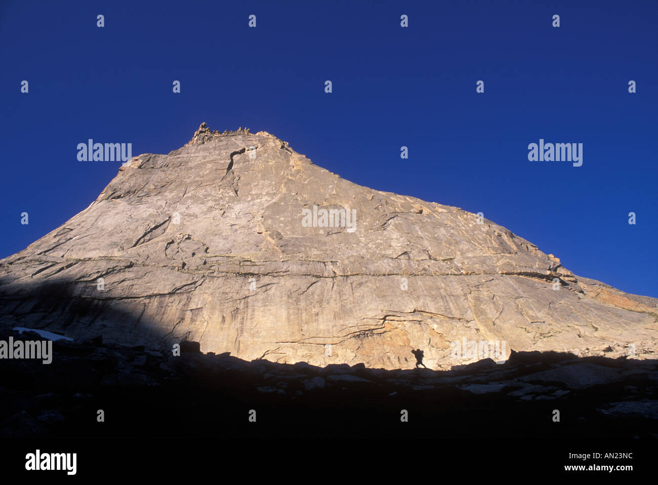 Hiker in front of a rock face Stock Photo