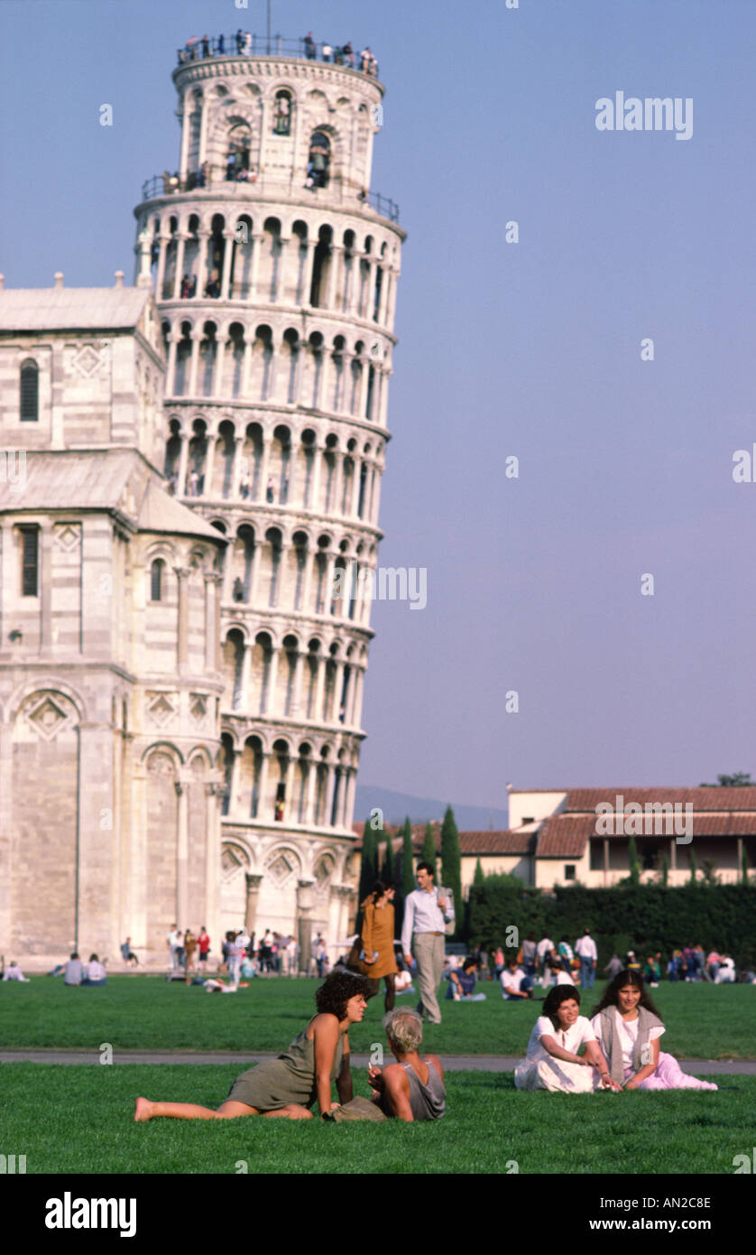 Leaning Tower of Pisa. Tuscany, Italy. Tourists relax in the Piazza Duomo in front of the tower and Duomo. Stock Photo