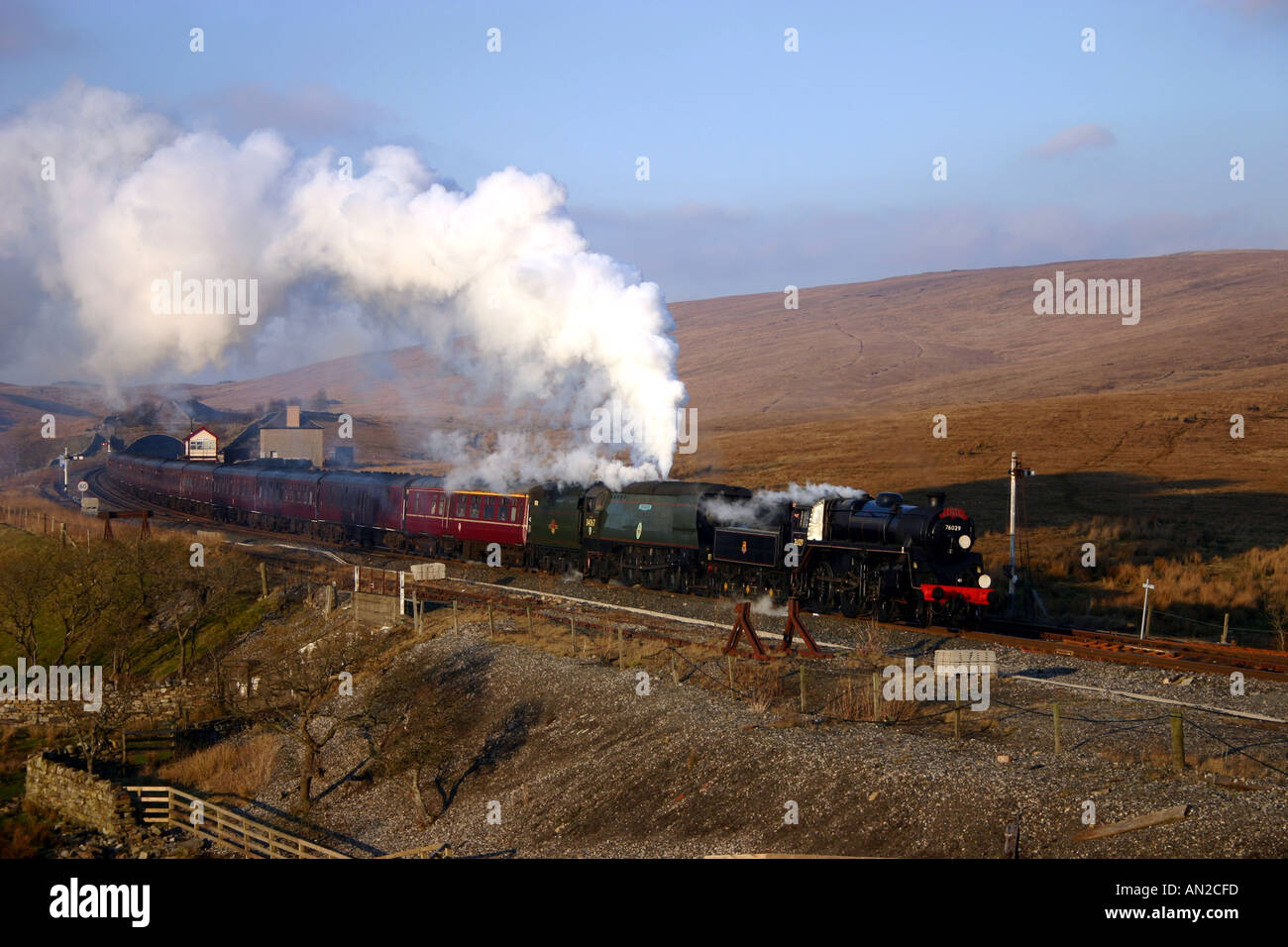 Steam special on the Settle to Carlisle railway line passing Blea Moor with locomotives 34067 Tangmere and 76029 on 21st February 2004. Stock Photo