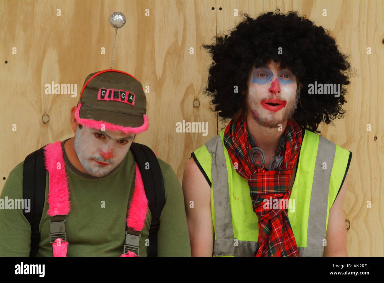 Two activists from the Clandestine Insurgent Rebel Clown Army looking dejected outside a boarded-up shop Stock Photo