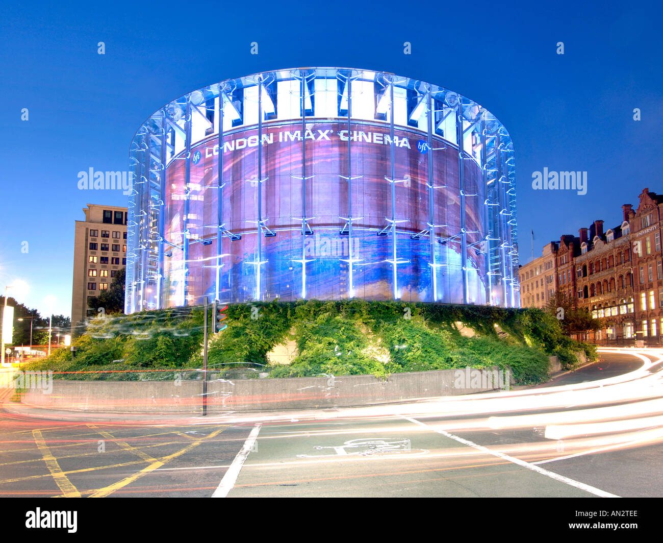London's IMAX cinema and light trails from passing traffic at dusk. Stock Photo