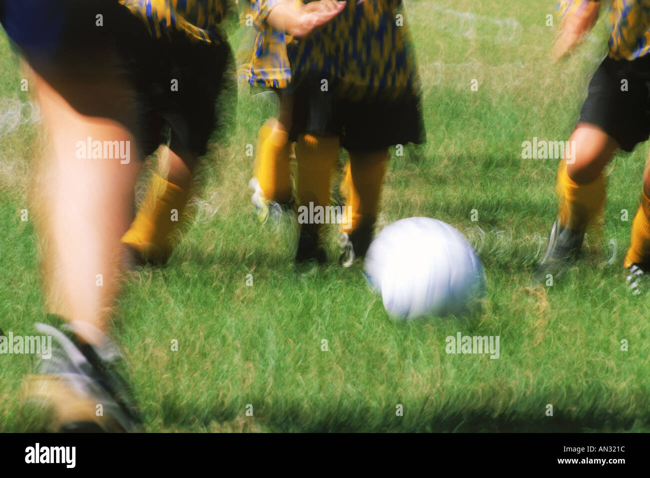 Kids legs in action playing soccer in California park Stock Photo