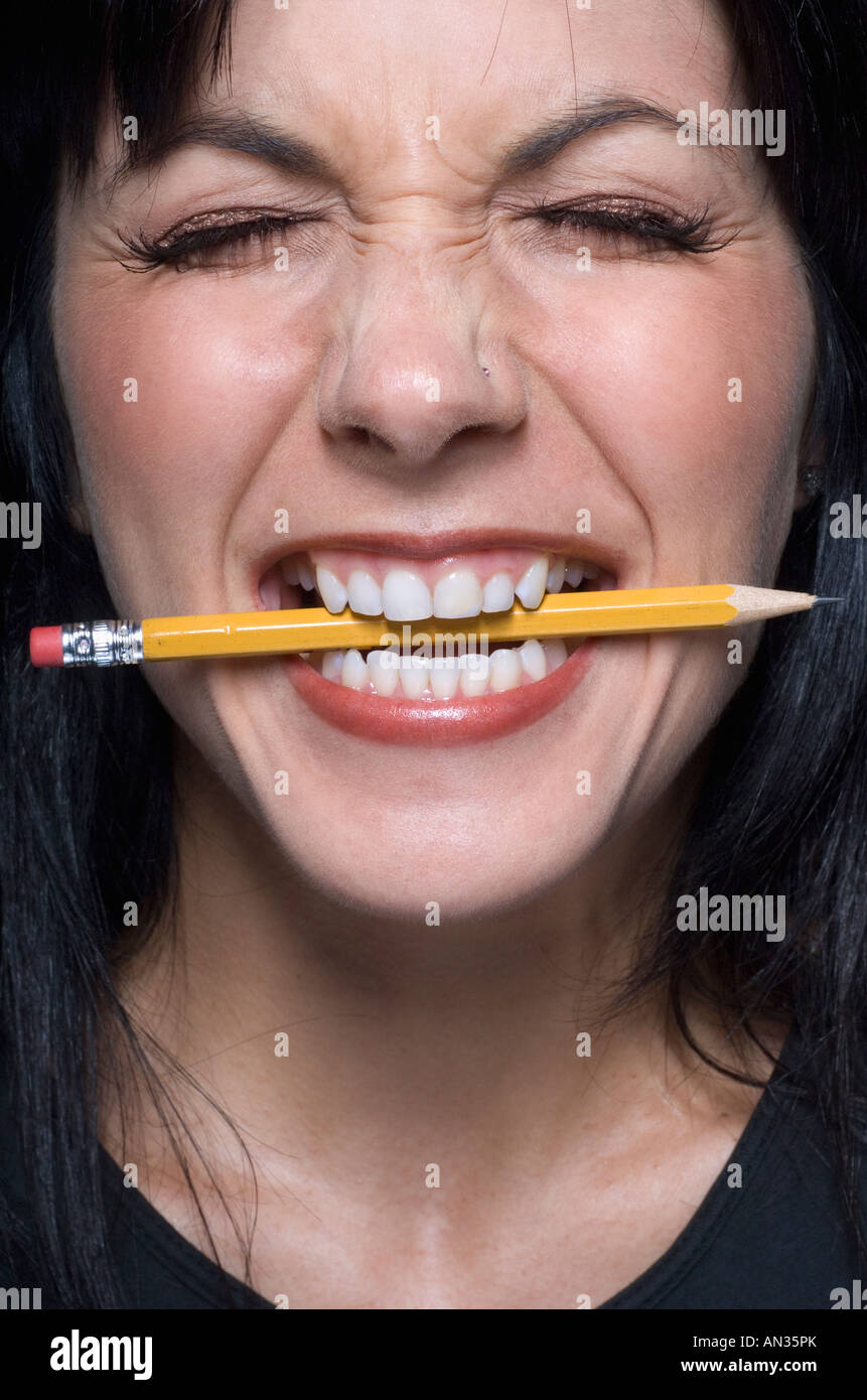 Close up of woman biting pencil Stock Photo
