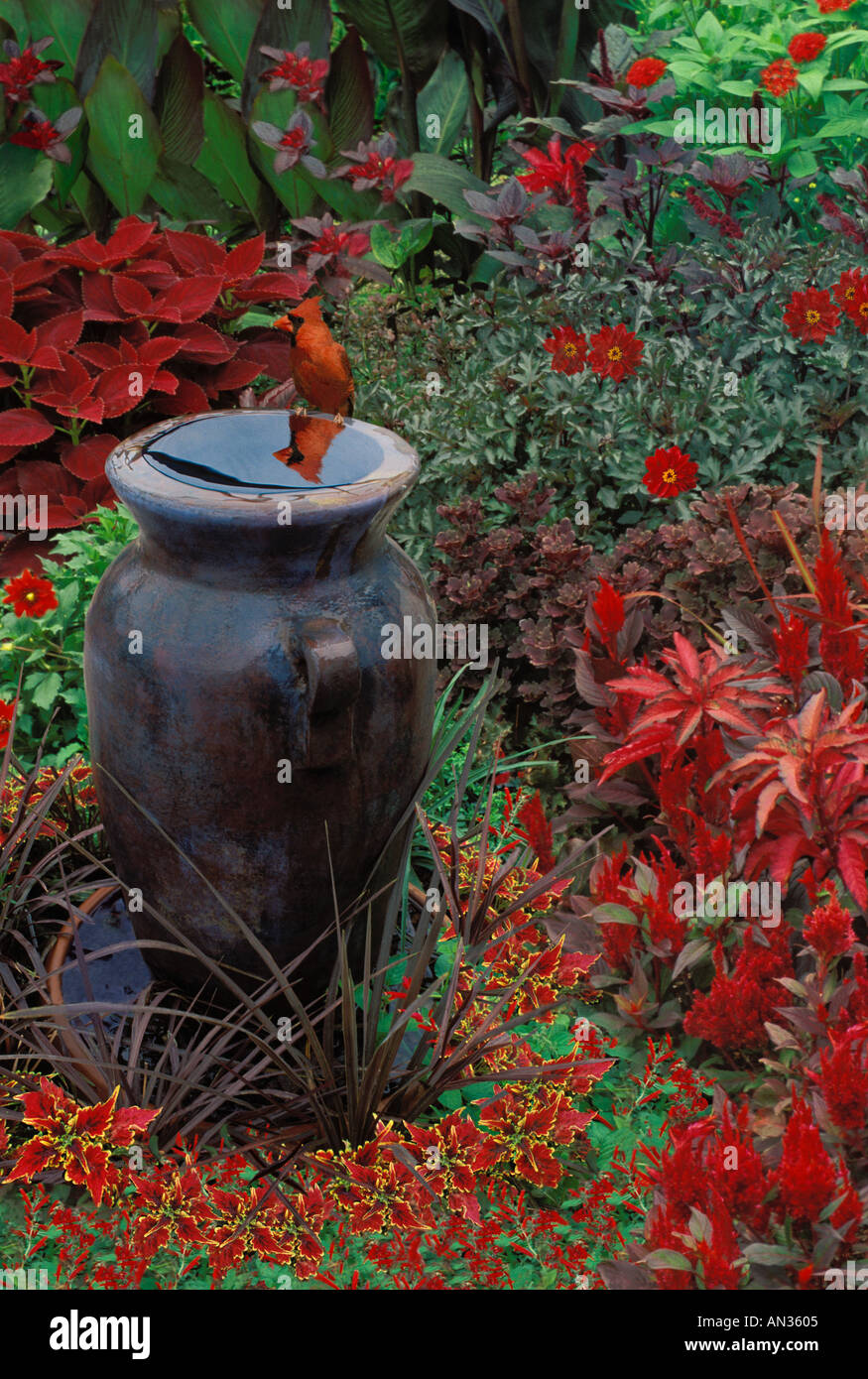 Flower Garden Of Red Colors And Tall Vase As Water Fountain With