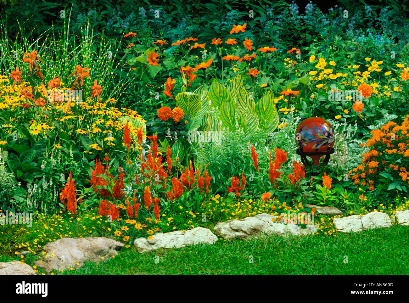 Flower garden with plants and fun handmade gazing globe of orange and