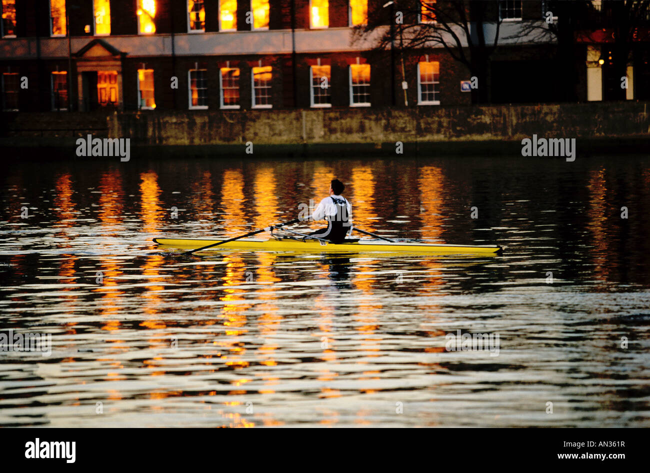 Man in skiff rowing on river Thames at sunset London England Stock Photo