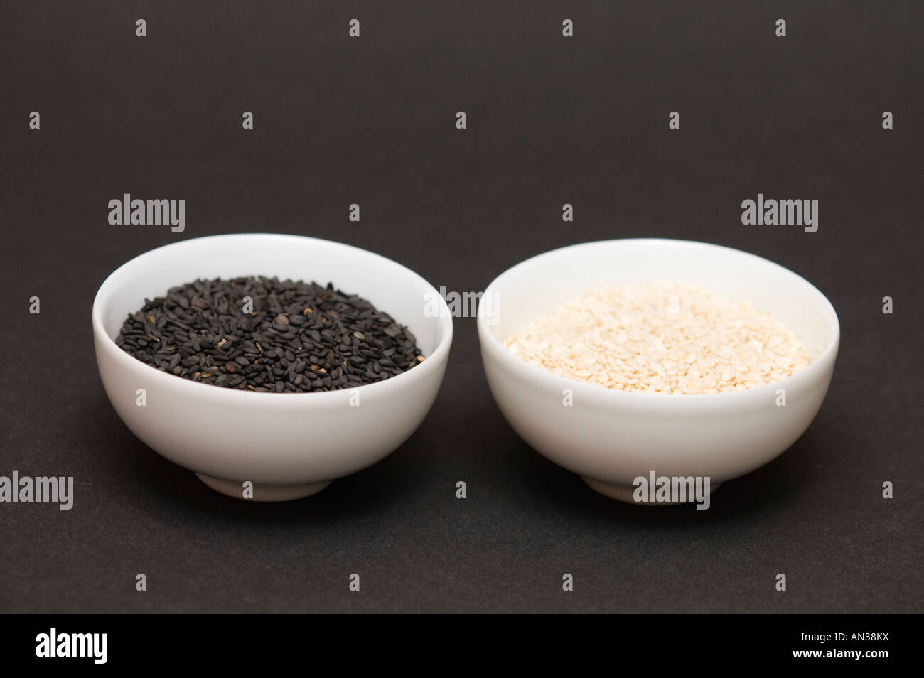 black and white sesame seeds in a bowls on dark background Stock Photo ...