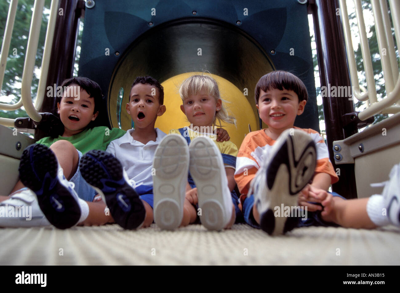 Multiethnic group of little children playing in playground Stock Photo