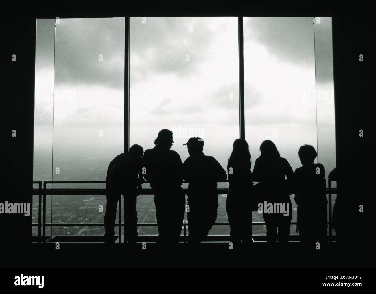 Silhouette of group of people looking out window of Sears Tower Chicago USA Stock Photo