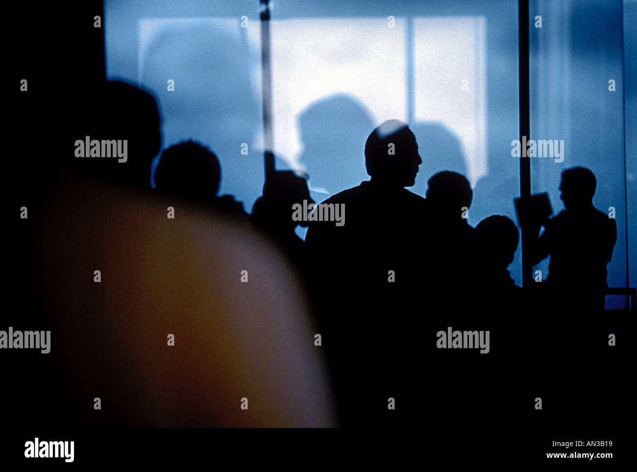 Silhouette of a crowd of people With reflectionsIn various windows Stock Photo