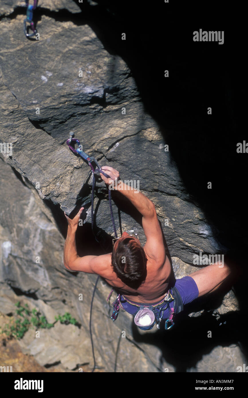 Rock climbing clipping his rope into a carabiner Stock Photo Alamy