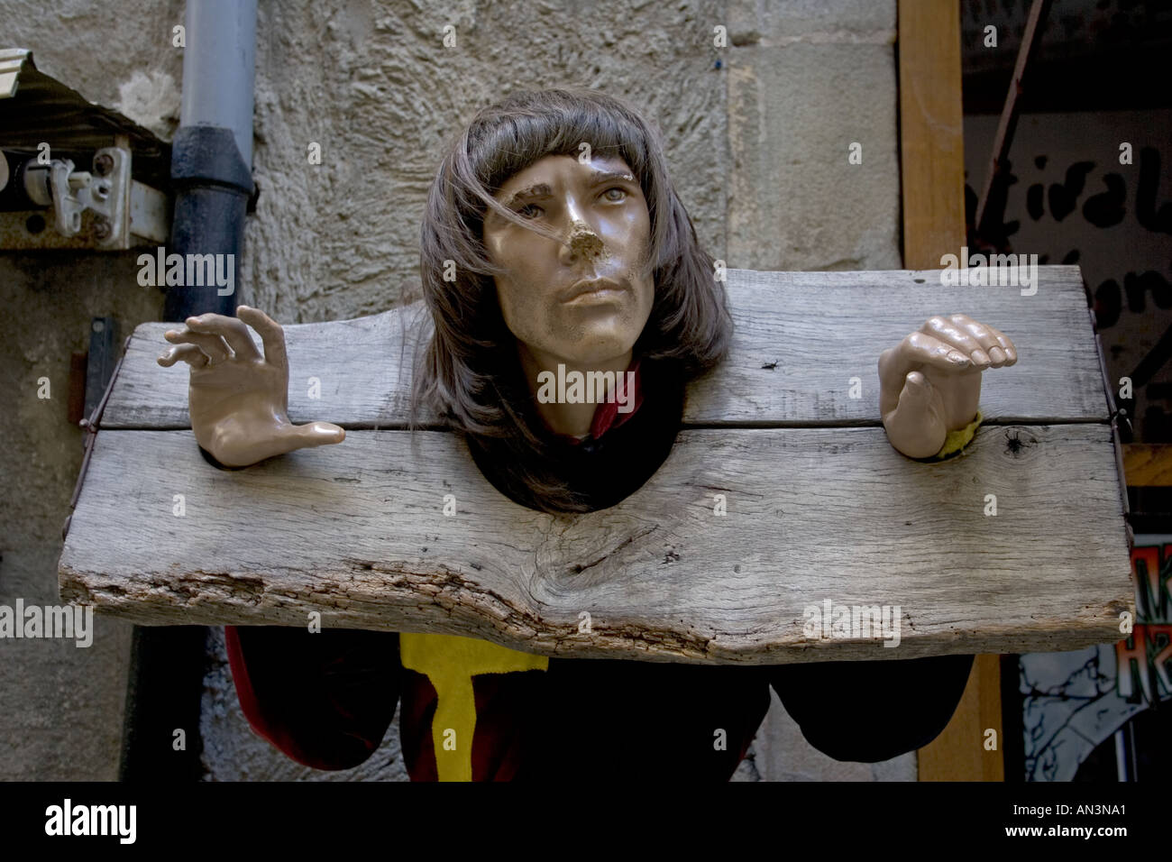 Sculpture of head of man in old wooden stocks in ancient fortified city of Carcassonne southern France Stock Photo