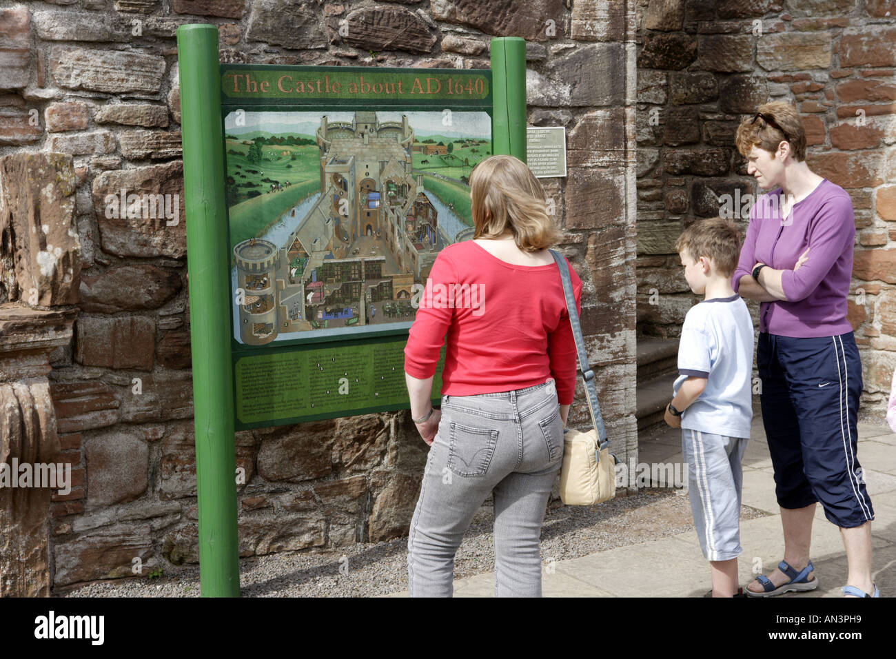 Visitors reading information board at Caerlaverock Castle Stock Photo