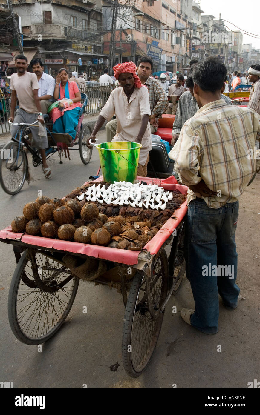 Rear view of  fresh coconut seller in the chaotic streets of Delhi Stock Photo