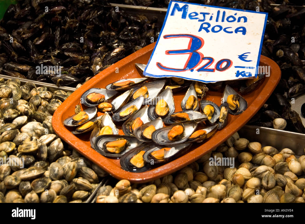 Fresh mussels and clams for sale on a stall in Mercat de La Boqueria food market on La Rambla Barcelona Spain  Stock Photo