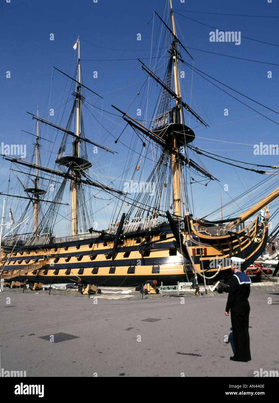 Portsmouth historic naval dockyard preserved HMS Victory Admiral Horatio Nelsons flagship at Battle of Trafalgar with sailor in uniform Hampshire UK Stock Photo