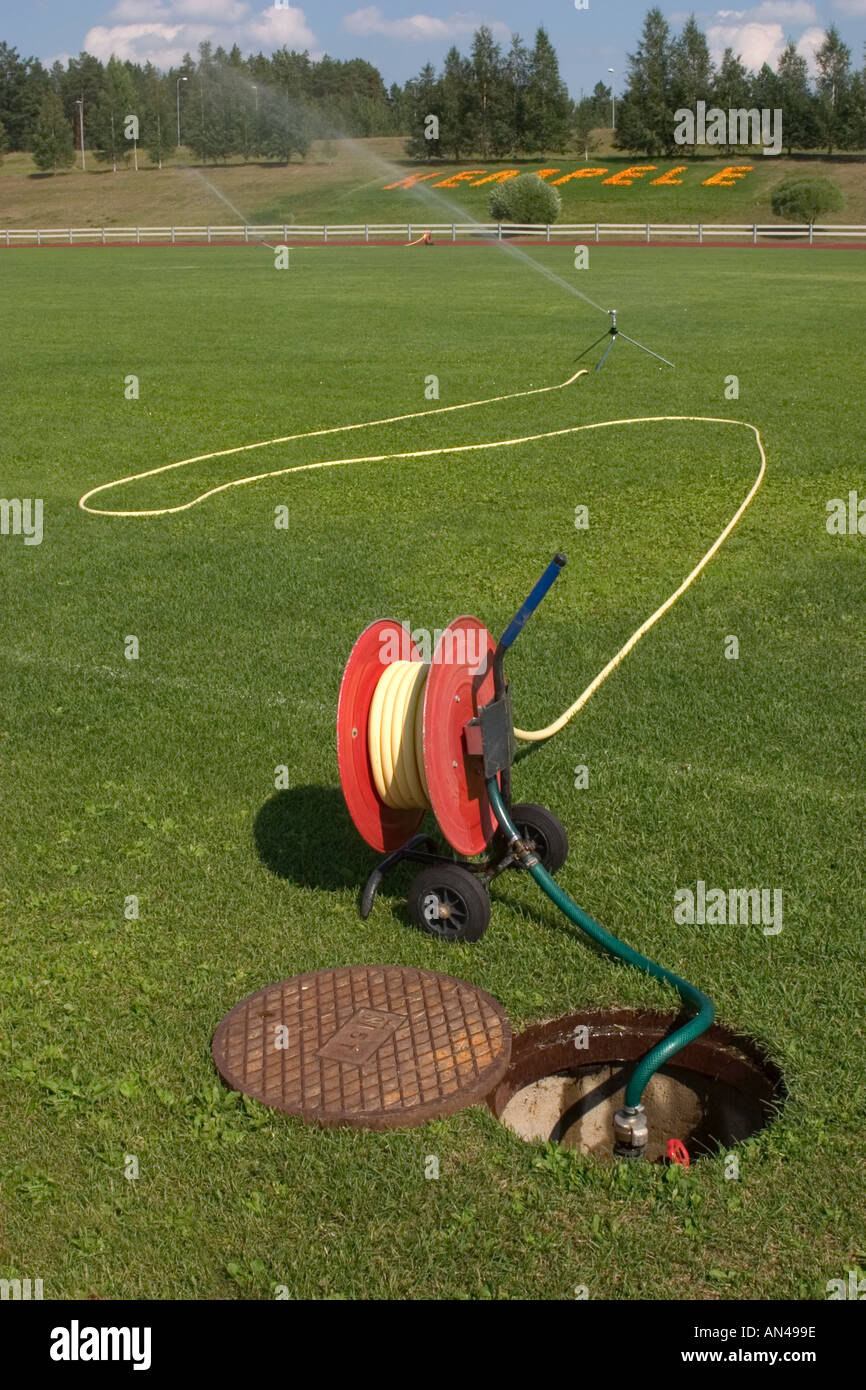 https://c8.alamy.com/comp/AN499E/water-tap-hose-reel-and-a-sprinkler-used-to-irrigate-the-lawn-of-a-AN499E.jpg