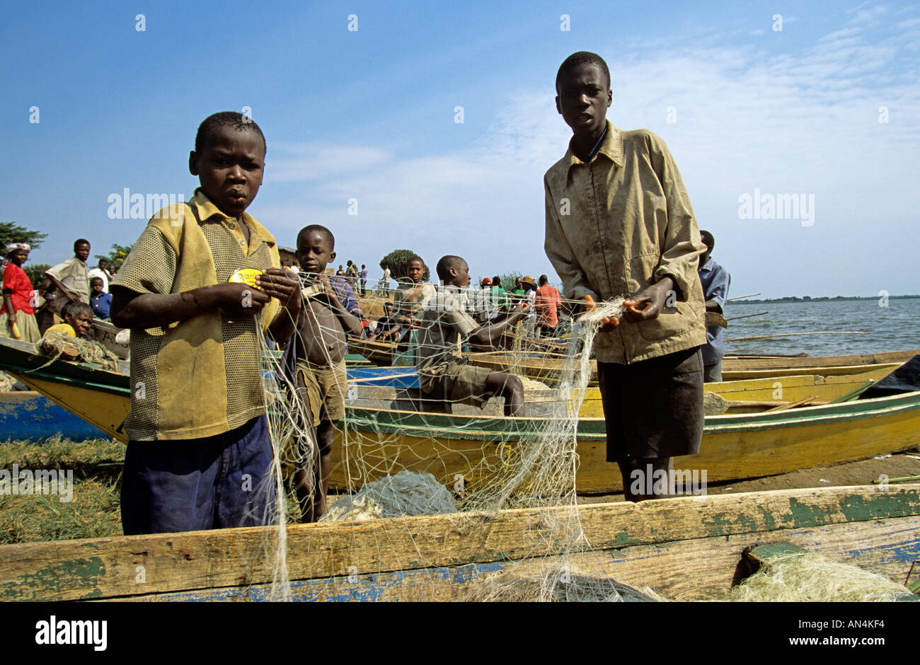 Group of villagers and children with fishing nets at sea, Western
