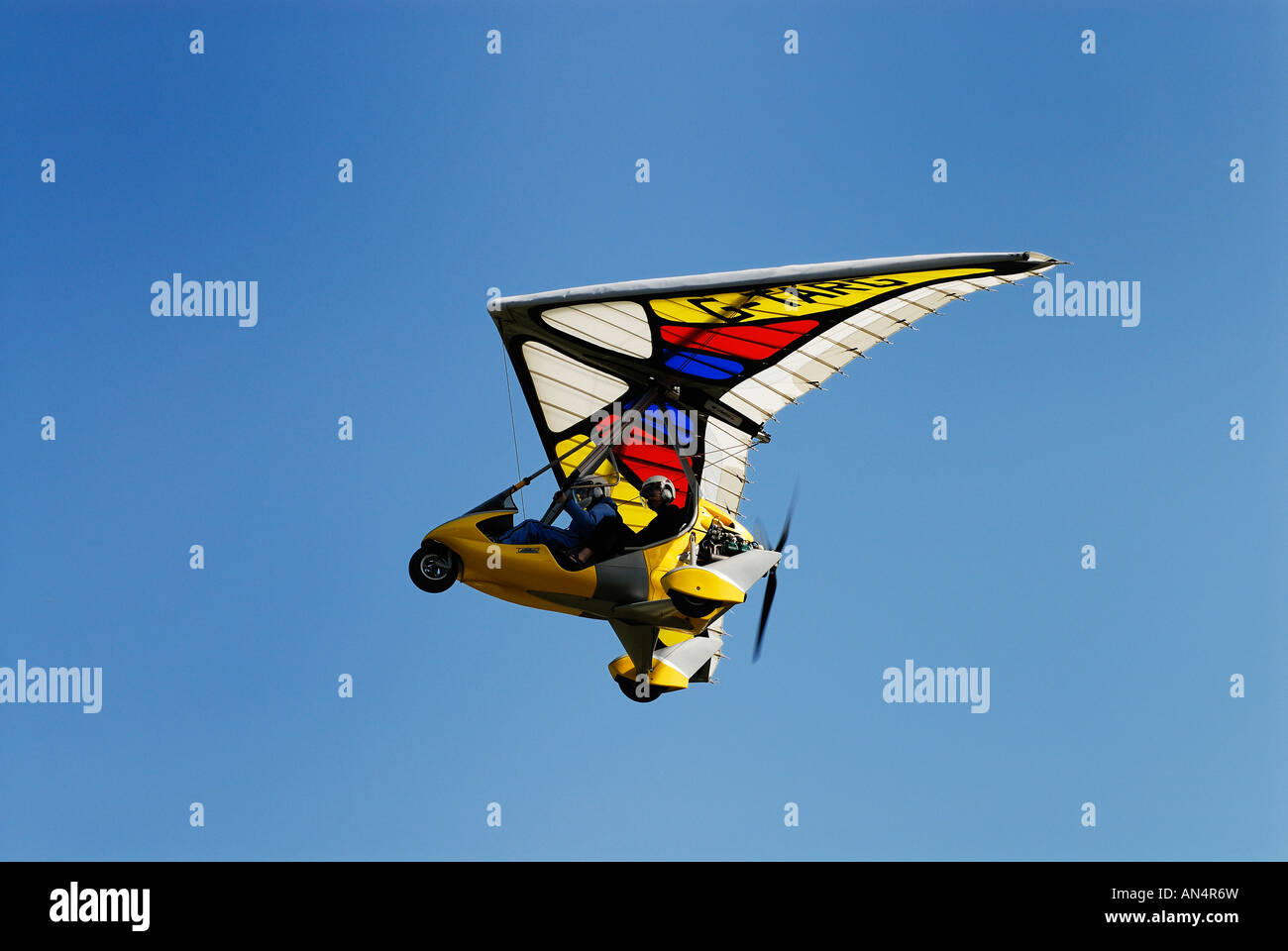Lovely yellow Tanarg Microlite takes off into a blue sky at Popham. Stock Photo