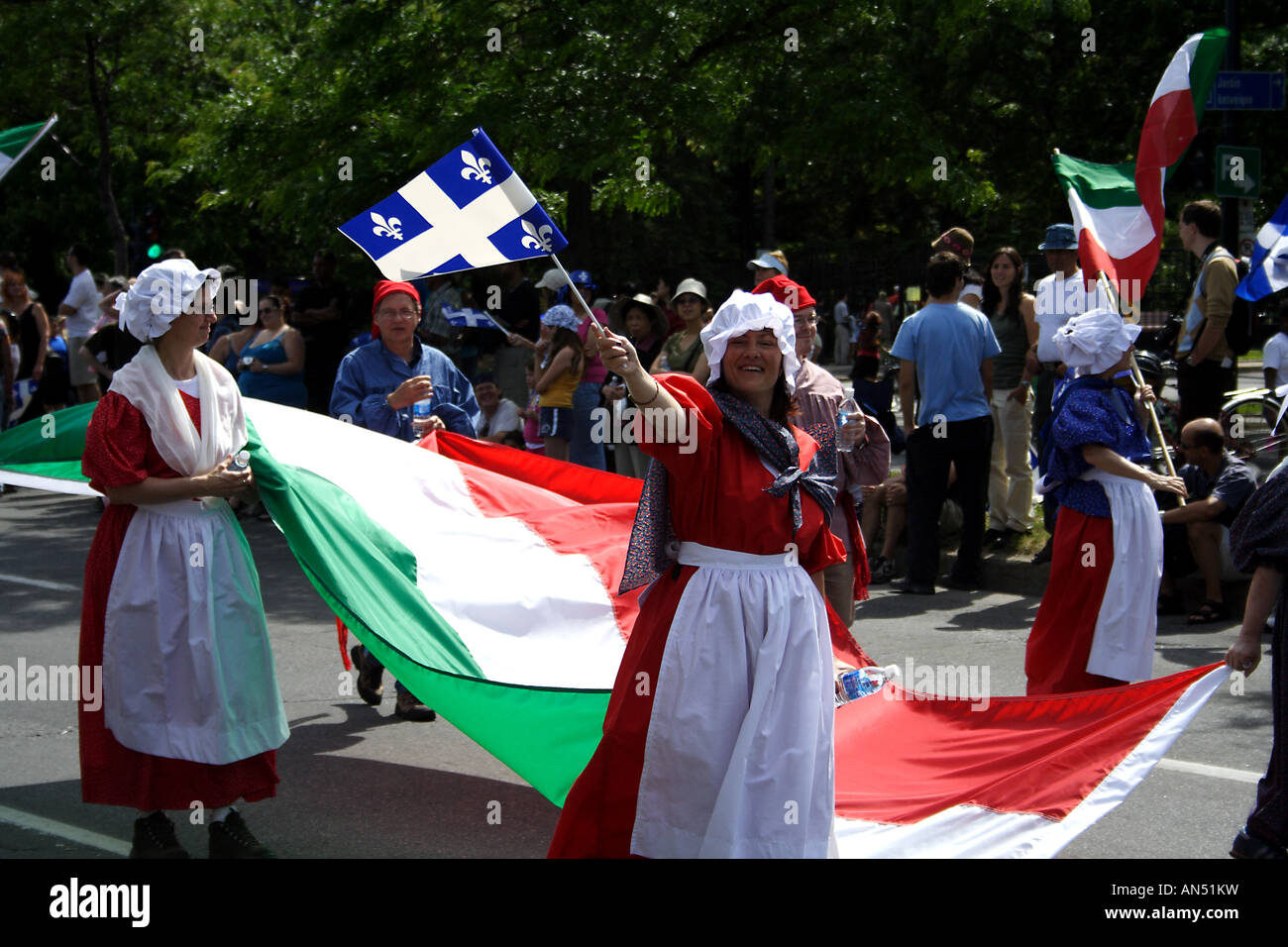 Woman waving a montreal flag while holding a hungarian flag in the Montreal Independence day parade Stock Photo