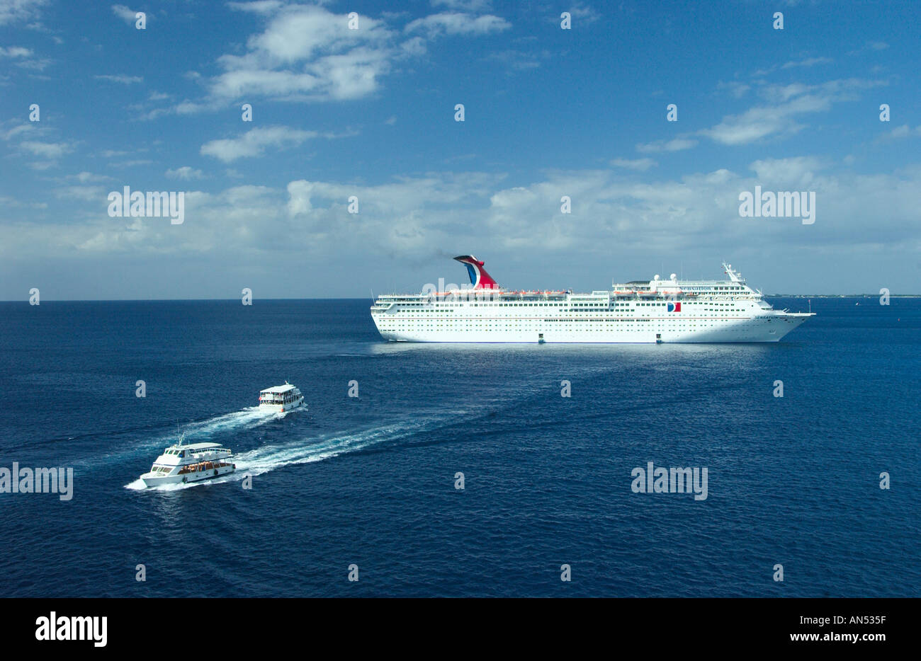 Carnival cruise ship Sensation with tender boat shuttling passengers