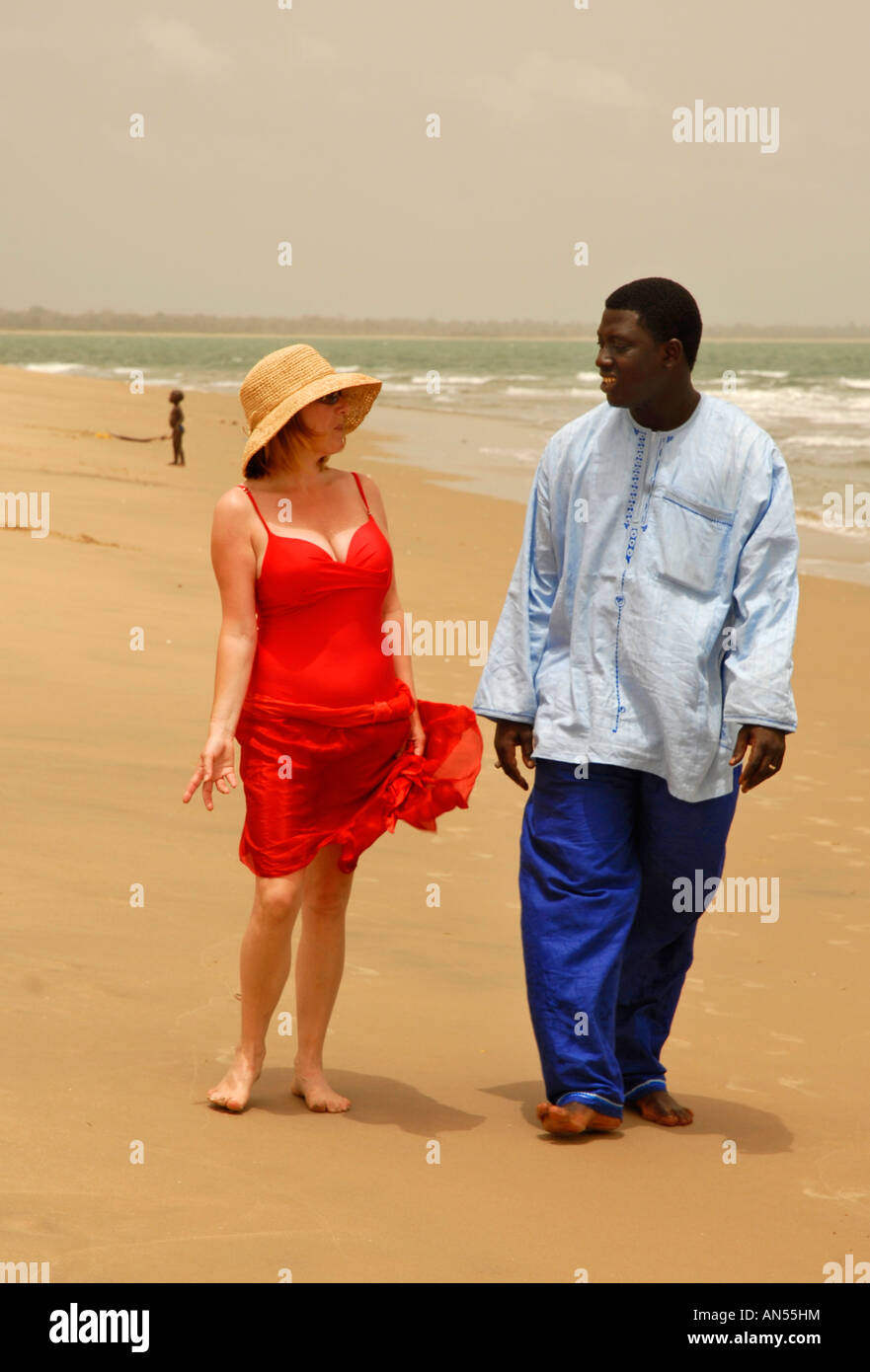 Gambian man talking with female tourist on the beach, The Gambia, West