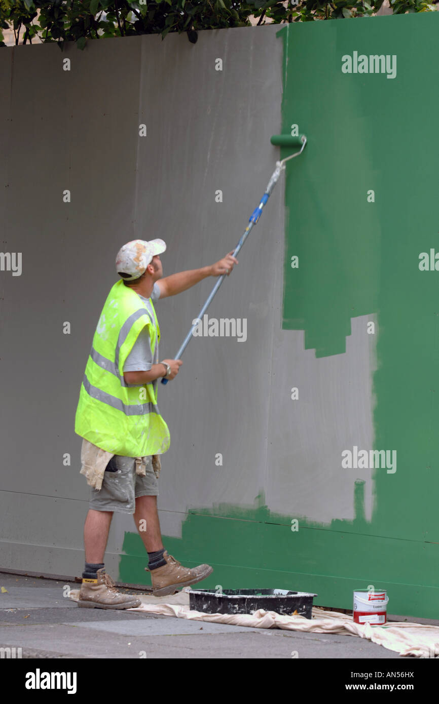 Man painting a fence green Stock Photo Alamy