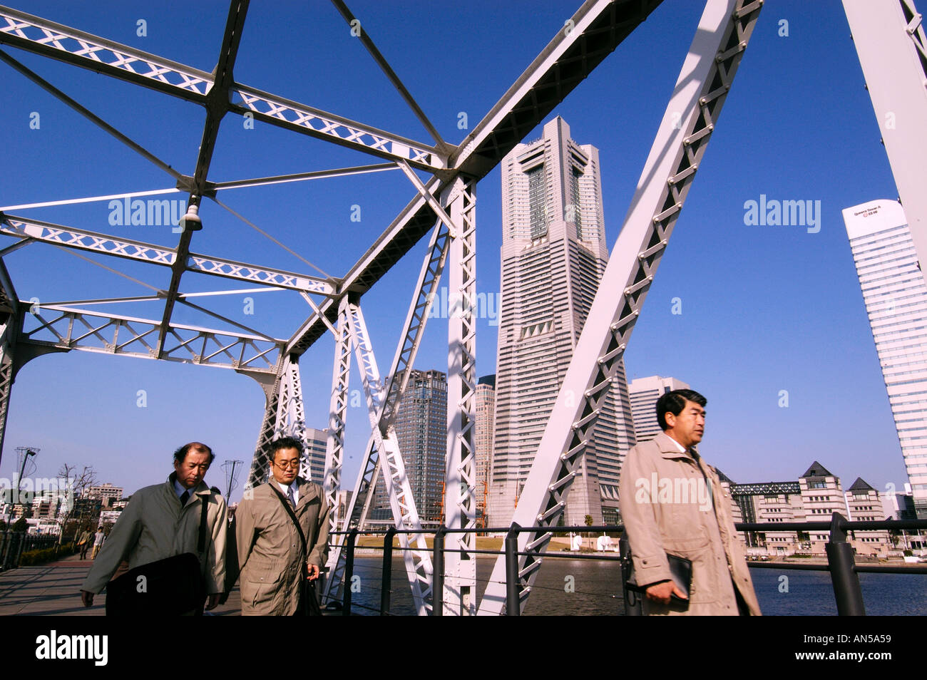 Office workers walk to work on bridge in futuristic Minato Mirai 21 development in Yokohama Japan 2005 Stock Photo