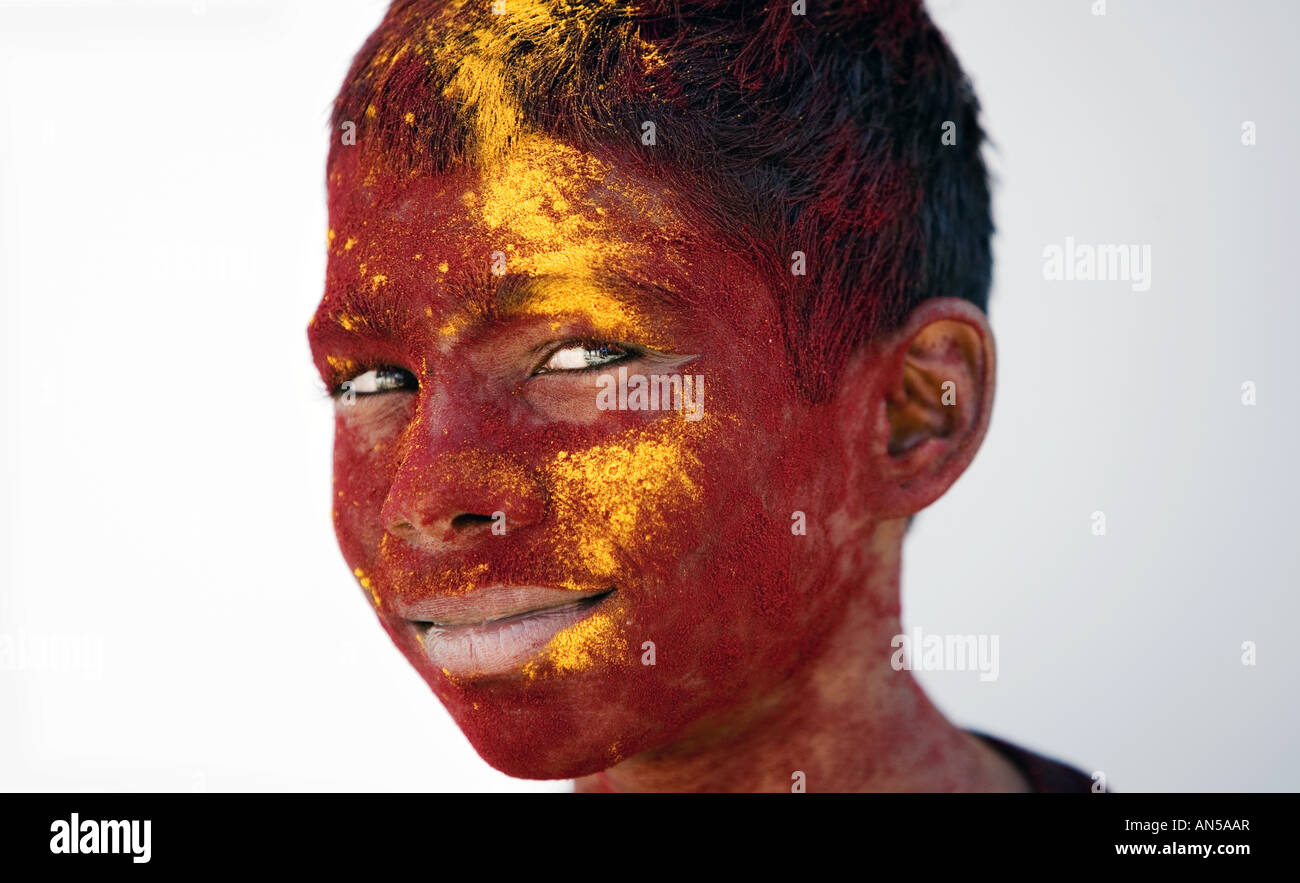 Indian boy covered in maroon and ochre coloured powder Stock Photo