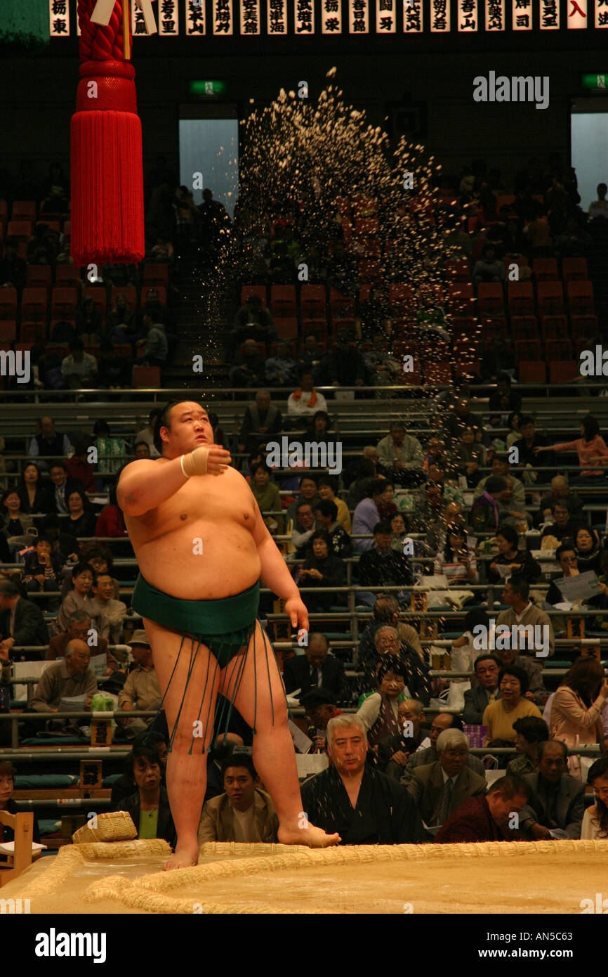 A sumo wrestler throws salt during his pre fight ritual ceremnoy at the Spring sumo tournament in Osaka Kansai Japan Asian sport Stock Photo