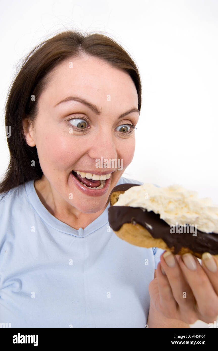 woman about to bite into a chocolate slice Stock Photo
