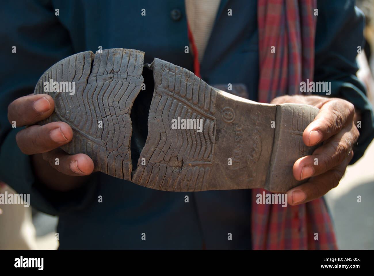 A participant of the Janadesh Walk for Land shows his broken shoes India 2007 Stock Photo