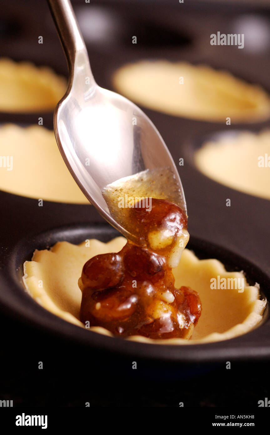 Filling mince pie pastry case with mincemeat filling using teaspoon
