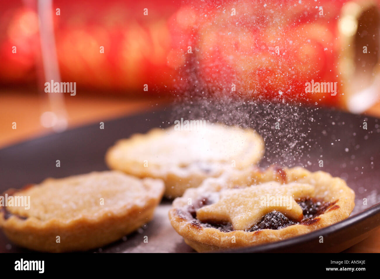 Dusting mince pies with icing sugar Stock Photo