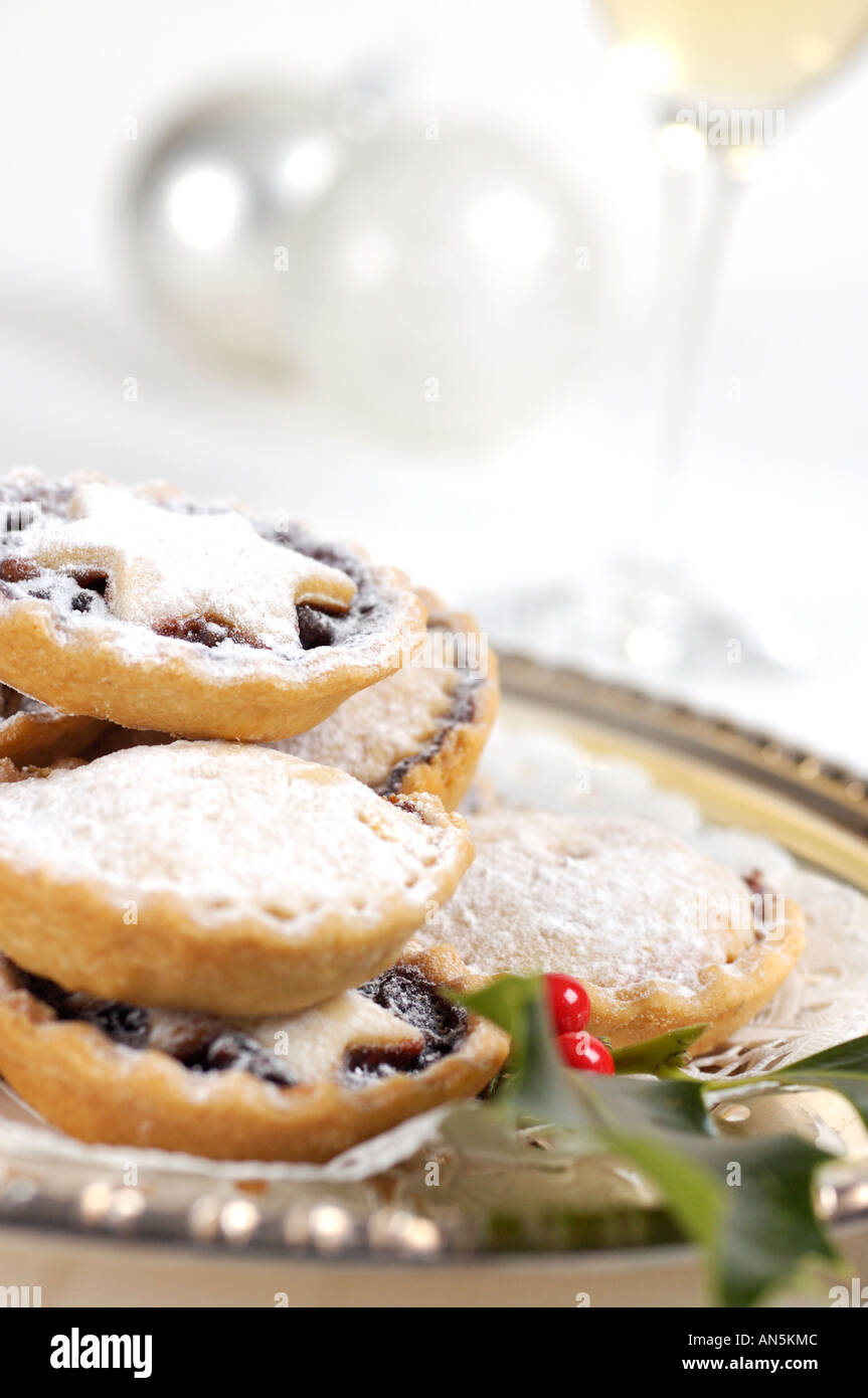 Plate of mince pies decorated with sprig of holly and with glass of ...