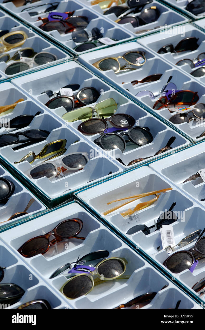 Display of cheap sunglasses on a market stall with the sun reflecting in the lenses Stock Photo