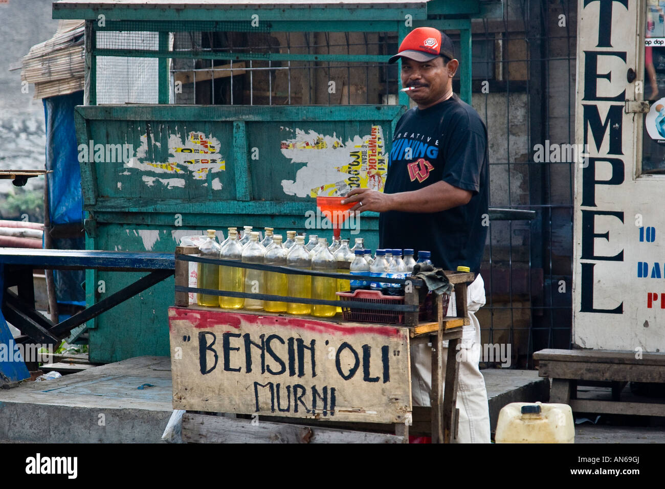 Man Smoking while Filling Gasoline Bottles Kota Jakarta Indonesia Stock Photo