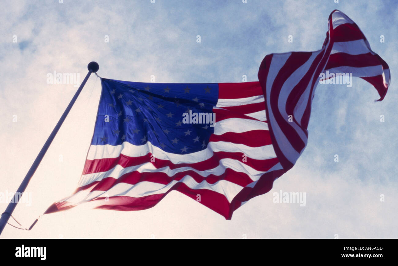 American flag blowing and rippling in the wind against a pale sky Stock Photo