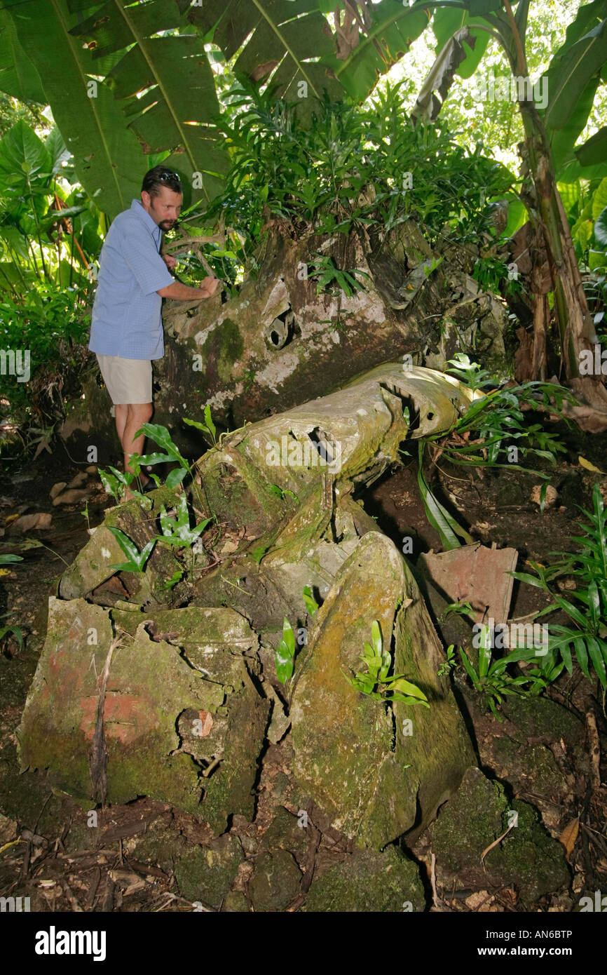 Visitor inspects remains of Japanese Zero fighter plane on Peleliu one of the bloodiest battles of the Pacific in WWII Stock Photo