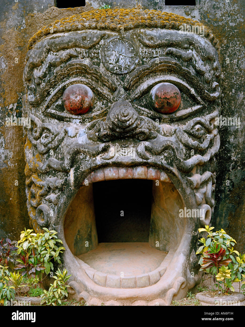 Entrance into the „pumpkin“ through the open mouth of a njak with a clock on his forehead Stock Photo