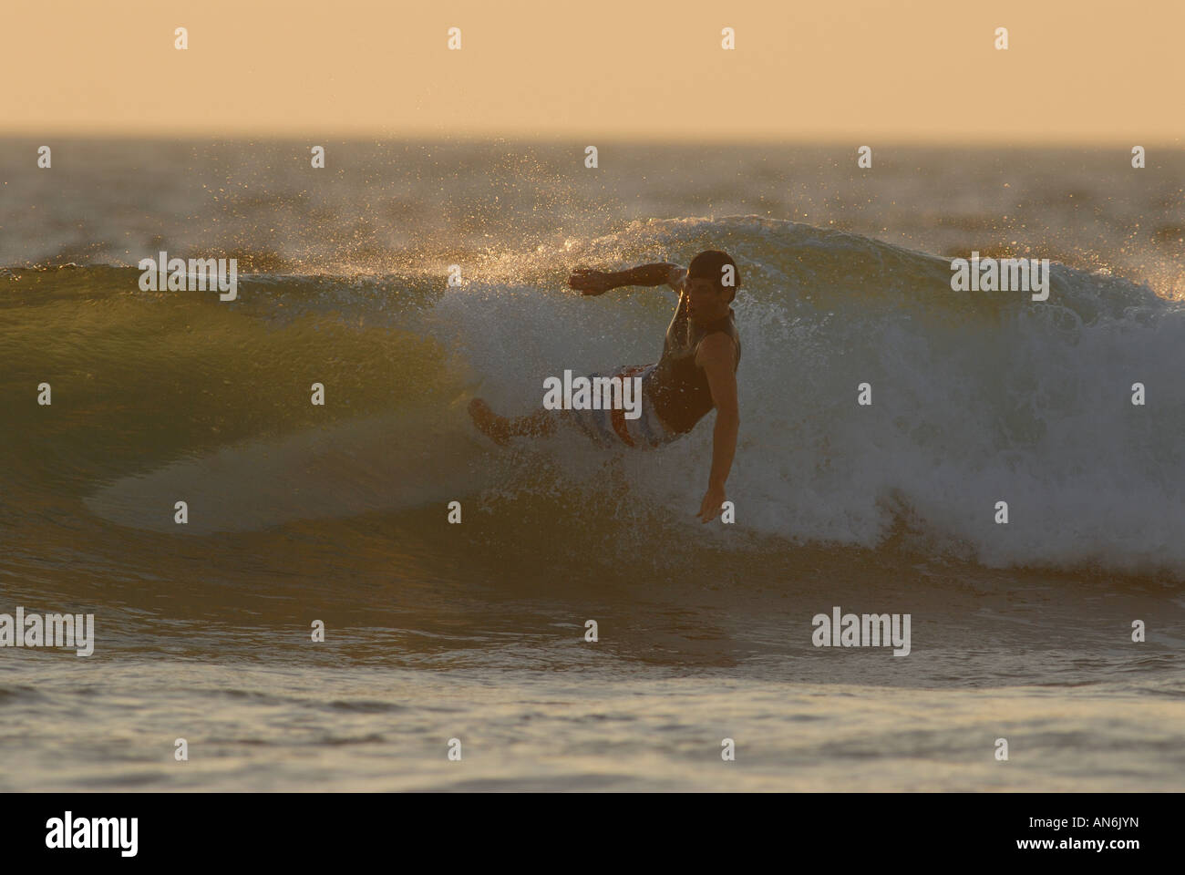 Early morning surfer falling off his Malibu board at small beach break ...