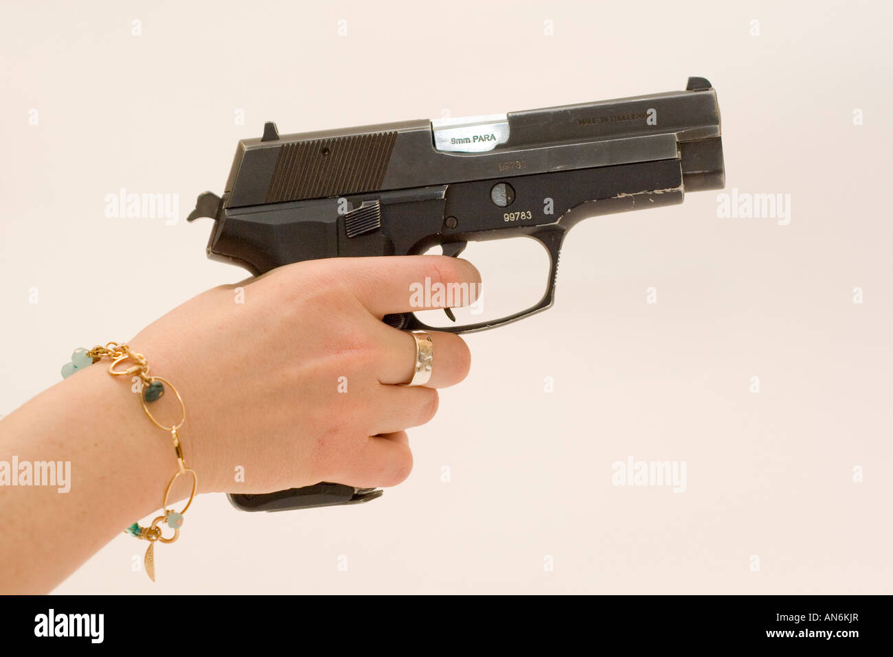 side view of a woman holding and aiming a Czech CZ 99 9mm parabelum semi automatic hand gun finger on trigger Stock Photo